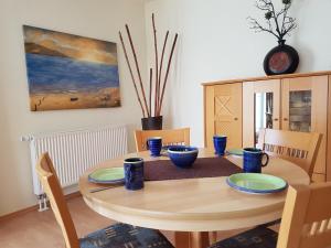 einen Esstisch mit blauen Gerichten darauf in der Unterkunft Strandoase Whg 14 in Heringsdorf