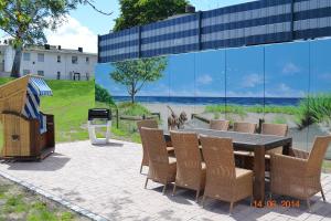 a dining table and chairs with a dog on the beach at Hamburg-App-05 in Ahlbeck