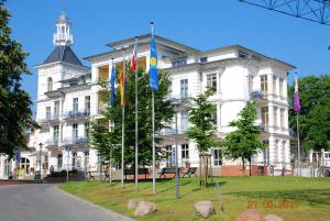 a large white building with flags in front of it at Seeschloss-App-05 in Heringsdorf