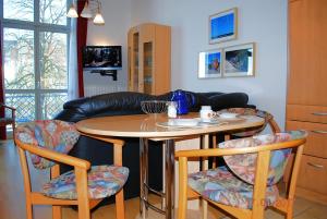eine Küche mit einem Tisch, Stühlen und einem Sofa in der Unterkunft Seeschloß App. 05 in Heringsdorf