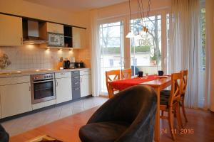 a kitchen and dining room with a table and chairs at Strandoase-Whg-16 in Heringsdorf +8 photos