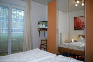 a bedroom with a bed and a tv and a window at Strandoase-Whg-16 in Heringsdorf