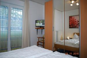 Schlafzimmer mit einem Bett, einem TV und einem Fenster in der Unterkunft Strandoase Whg 16 in Heringsdorf