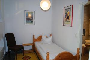 ein kleines Schlafzimmer mit einem Bett und einem Stuhl in der Unterkunft Vineta App. 6/7 in Bansin