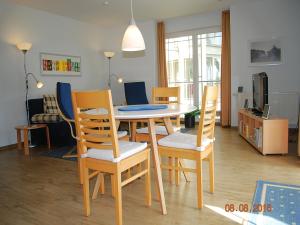 a dining table and chairs in a living room at Strandoase-App-04 in Heringsdorf