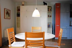 a dining room with a table and chairs and a light at Strandoase-App-04 in Heringsdorf