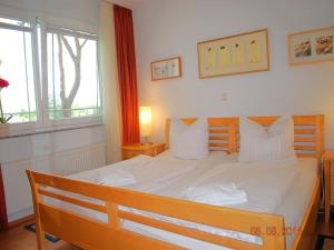Schlafzimmer mit einem großen weißen Bett und einem Fenster in der Unterkunft Strandoase App. 04 in Heringsdorf