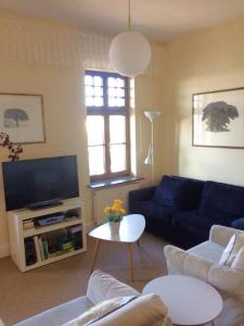 ein Wohnzimmer mit einem blauen Sofa und einem TV in der Unterkunft Strandklause App. 06 in Bansin