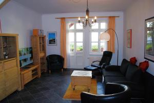ein Wohnzimmer mit einem schwarzen Sofa und einem Tisch in der Unterkunft Vineta App. 6/7 in Bansin