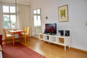 un soggiorno con TV e tavolo da pranzo di Haus-Wanda-App-06 a Ahlbeck