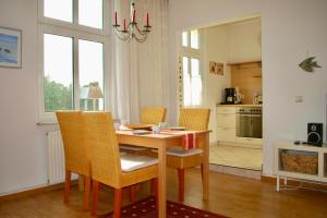 una cucina con tavolo da pranzo e sedie di Haus-Wanda-App-06 a Ahlbeck