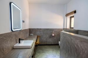 un baño con lavabo y espejo en Swisscocobeach, en Nosy Be