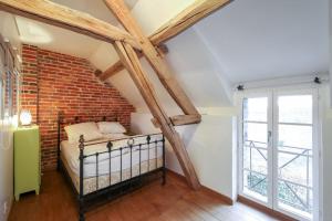 a bedroom with a bed in a brick wall at LES DENISOTS 12/14 PERS PISCINE PRIVEE in Lavau