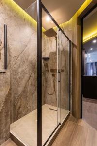 La salle de bains est pourvue d'une douche avec une porte en verre. dans l'établissement Luxury apartment in the superb location, à Chişinău