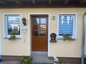 a house with a wooden door and two windows at Ferienwohnung „Thea“ in Bad Lausick
