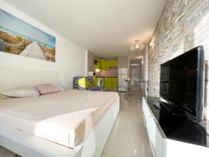 Schlafzimmer mit einem großen Bett und einem großen Flachbild-TV in der Unterkunft Studioapartment Borinquen in Playa Fañabe