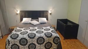 a bedroom with a bed with a black and white comforter at Apartment Puijo & autotalli in Kuopio