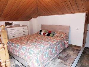a bedroom with a bed and a wooden ceiling at Casa ORI in Perledo