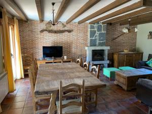 a dining room with a table and a brick wall at Casa Rural El Corral in Ávila
