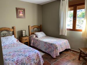 アビラにあるCasa Rural El Corralのベッドルーム1室(ベッド2台、窓付)