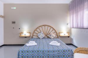 ein Schlafzimmer mit einem Bett mit zwei weißen Schuhen darauf in der Unterkunft A casa di Pietro Due in Leporano