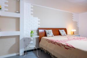 - une chambre avec un lit et un mur en briques blanches dans l'établissement A casa di Pietro Tre, à Leporano