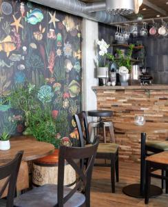 un ristorante con tavoli e sedie e un murale di Havshotellet a Malmö