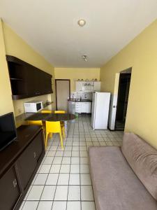 uma cozinha com um sofá, uma mesa e um frigorífico em Navegantes apartamento no Recife