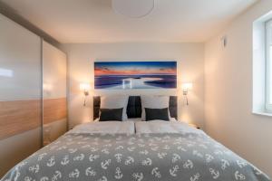 a bedroom with a bed with a painting on the wall at Ferienwohnung Ankergold in Nordstrand