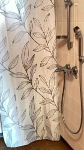 un rideau de douche avec un motif foliaire sur un mur dans l'établissement Omakotitalo 100m2, 3 makuuhuonetta Joensuu, à Joensuu