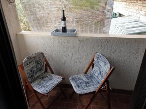 2 sillas sentadas en un porche con una botella de vino en Room BM, en Pula
