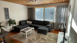 a living room with a couch and a table at Omakotitalo 100m2, 3 makuuhuonetta Joensuu in Joensuu