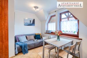 ein Wohnzimmer mit einem Sofa und einem Tisch in der Unterkunft Apartamenty Rodzinne ApartZakop in Zakopane
