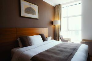 a hotel room with a large bed with a window at Nour Al Thuria Hotel in Makkah