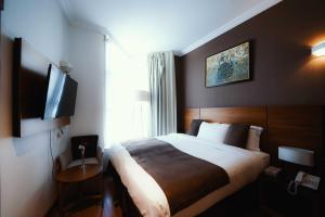 a hotel room with a bed and a flat screen tv at Nour Althuria Hotel - Elaf Almaqam in Makkah