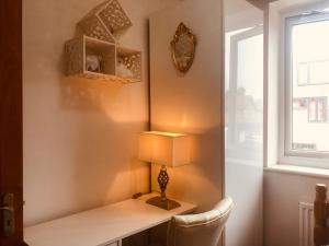 a room with a desk with a lamp and a window at Cheerful 4 bedroom house with garden free parking in London