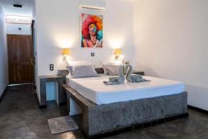Un dormitorio con dos camas y un cuadro en la pared. en Swisscocobeach, en Nosy Be