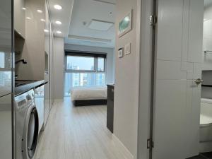 a room with a bed and a bathroom with a washing machine at Central City in Incheon