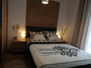 1 dormitorio con 1 cama con edredón blanco y negro en Apartament Grapa 29 K3 na terenie Sun & Snow Białka Tatrzańska, en Białka Tatrzanska