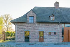 a brick house with a brown door and windows at Les jardins du Quesnoy - 25min de Pairi Daiza in Blicquy