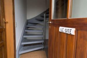 a staircase in a room with a sign on the door at Les jardins du Quesnoy - 25min de Pairi Daiza in Blicquy