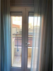 Luxury Rooms Padova Station في بادوفا: زوج من الأبواب الزجاجية مع إطلالة على شرفة