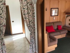 una sala de estar con un sofá marrón con almohadas rojas en Affittacamere Iragidor, en Cortina dʼAmpezzo