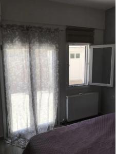 Pachia AmmosにあるCountry Houseのベッドルーム1室(ベッド1台付)、窓2つ(カーテン付)