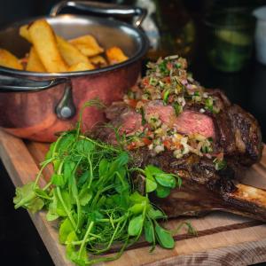 un plato de carne y patatas fritas en una tabla de cortar en The Seaview, East Preston, en Littlehampton