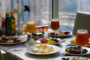 Nour Al Thuria Hotel في مكة المكرمة: طاولة مع أطباق من الطعام وكؤوس من العصير