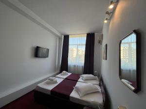 a hotel room with a bed and a window at Hotel Tineretului in Bucharest