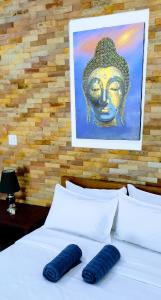 a bed with two pillows and a painting on the wall at Number SIX house for up to 5 guests with 2 bedrooms in Ko Samed