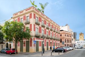 un edificio rojo en una calle de la ciudad con coches aparcados en CSE San Bernardo, en Sevilla