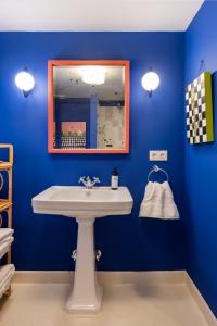 baño con lavabo blanco y pared azul en CSE San Bernardo, en Sevilla